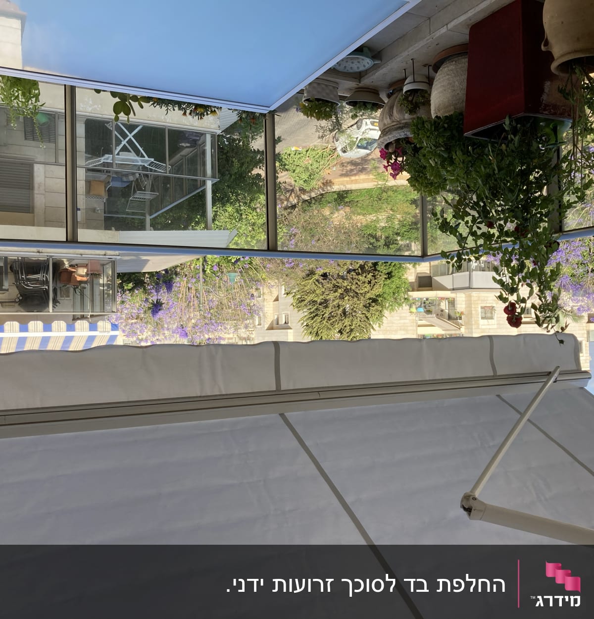 סוכך לבן עם זרועות מתכת על רקע שמיים כחולים